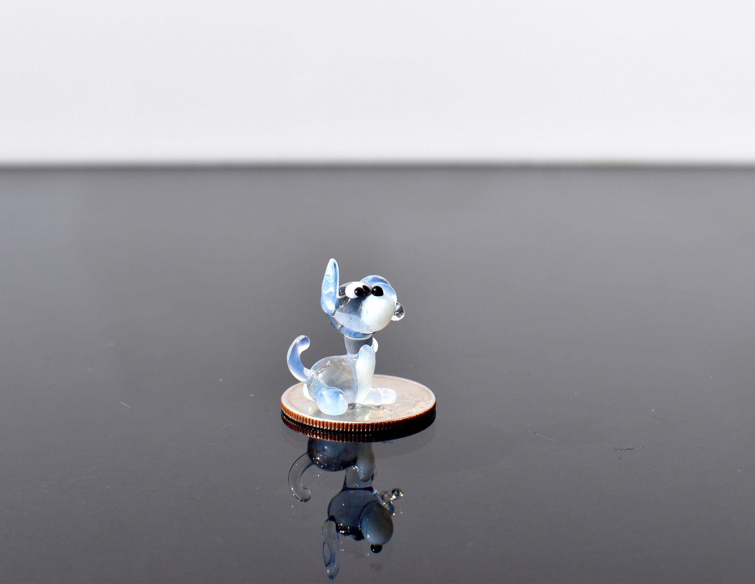 Cute Tiny light blue glass dog. Whimsical figurine with a lot of character and personality. Excellent addition to your collection.