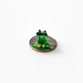 May include: A small green glass frog figurine sitting on top of a US quarter coin.