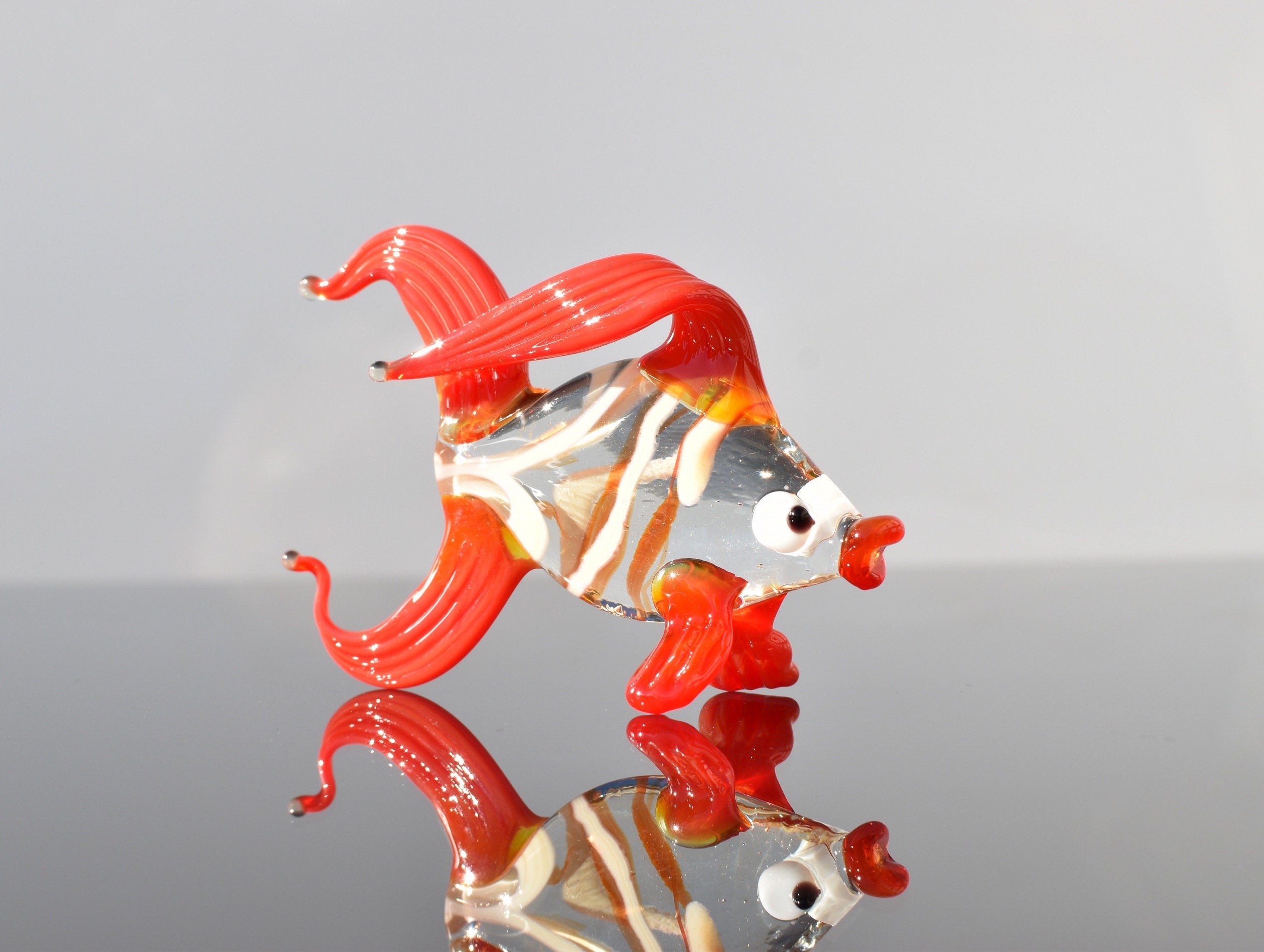 Cute Glass red-clear colorful goldfish. Detailed figurine with a lot of character and personality.  Excellent addition to your collection.
