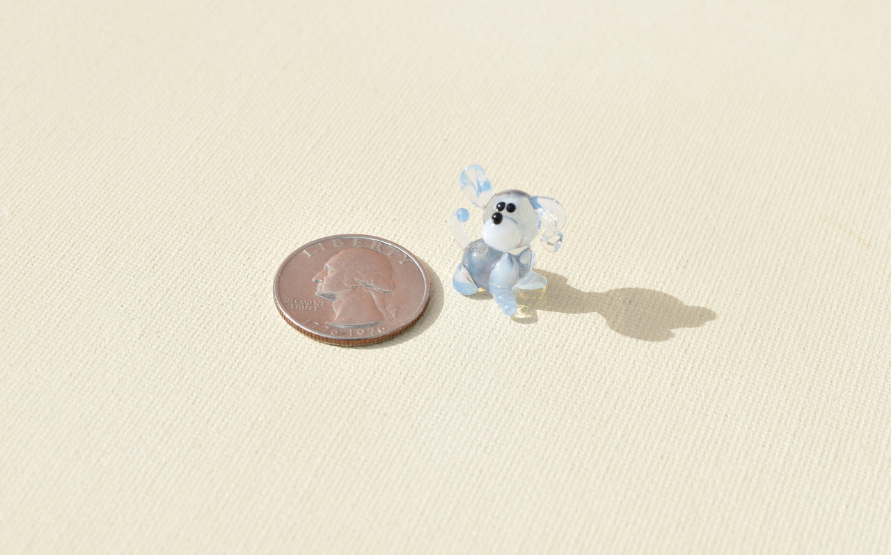 Cute Tiny light blue glass dog. Whimsical figurine with a lot of character and personality. Excellent addition to your collection.