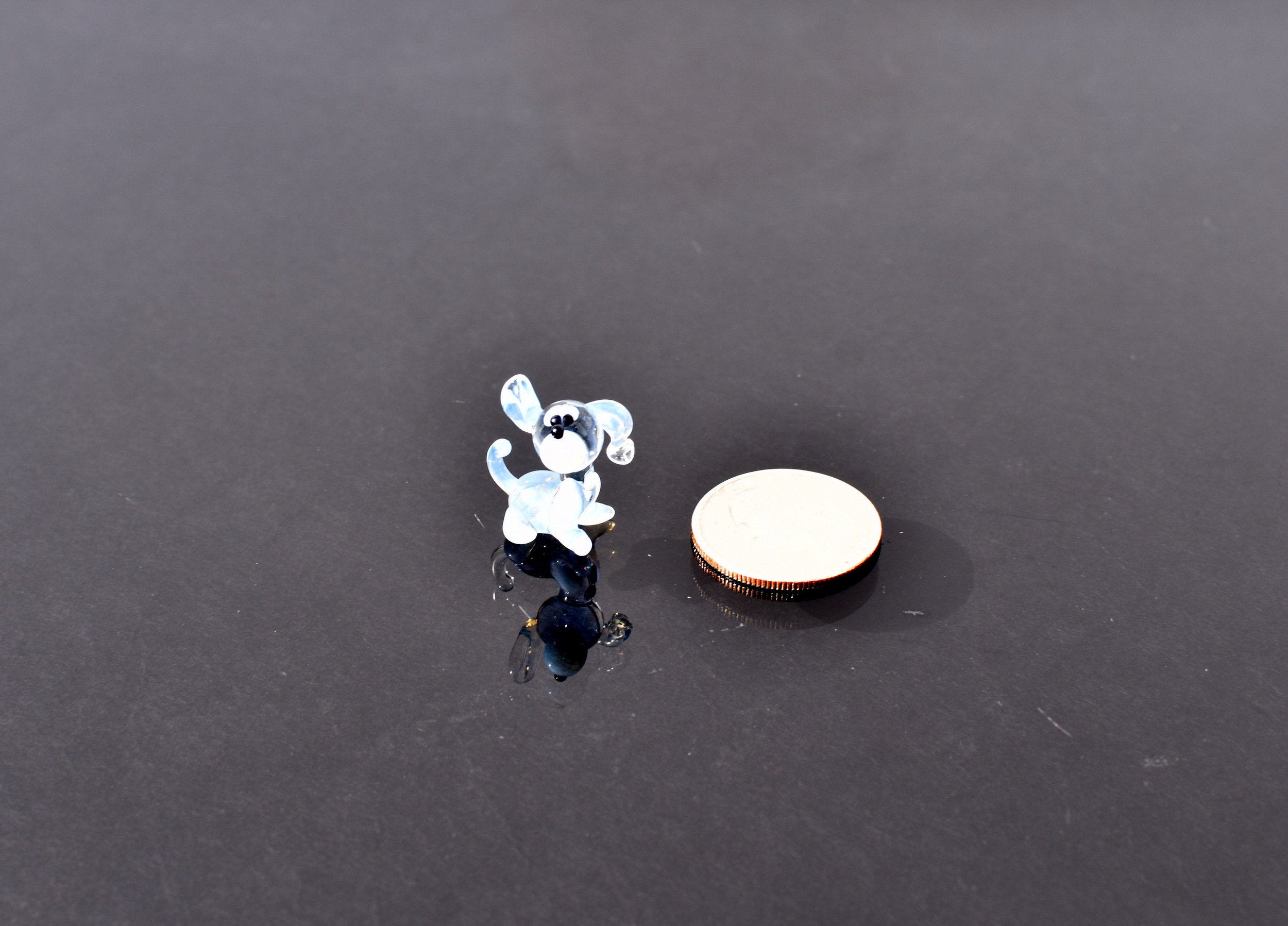 Cute Tiny light blue glass dog. Whimsical figurine with a lot of character and personality. Excellent addition to your collection.