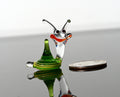 May include: A small glass snail figurine with a green and yellow striped shell, clear body, and red and white eyes.